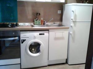 a kitchen with a washing machine and a refrigerator at Gite des Carcis in Ganac