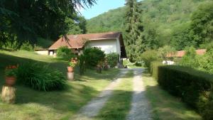 a house with a pathway leading to a yard with flowers at Gite des Carcis in Ganac