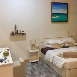a bedroom with a bed and a desk with a lamp at South Ari Inn in Mandhoo +26 photos