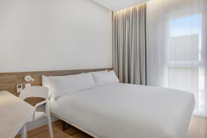 a bedroom with a large white bed and a window at B&B HOTEL Murcia Thader in Churra