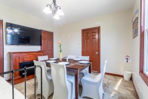a dining room with a wooden table and white chairs at One Bus Stop to Time Square-4BR Duplex-Free Parking in Hillside