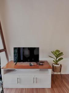 a tv sitting on top of a white entertainment center at Balay @ Santa Fe, Bantayan in Pooc