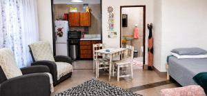 a small room with a bed and a kitchen at Peacock Cove Self Catering Studio in Gordonʼs Bay +10 photos
