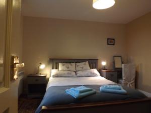 a bedroom with a bed with two towels on it at Small cosy bothy in Dingwall