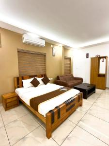 a bedroom with a large bed and a couch at Wayanad Way Resort in Koroth