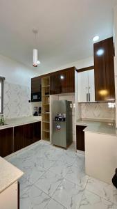 a large kitchen with a refrigerator and wooden cabinets at Flat in lekki2 bed apartment in Lekki