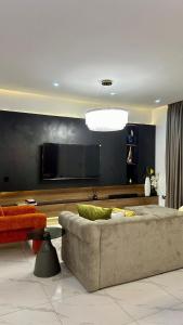 a living room with a couch and a flat screen tv at Flat in lekki2 bed apartment in Lekki
