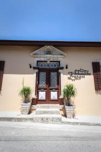 a building with a wooden door with two potted plants at Arhontiko Frangos in Kato Drys