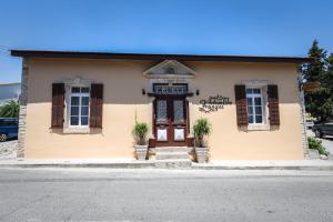 a small yellow building with a door and windows at Arhontiko Frangos in Kato Drys