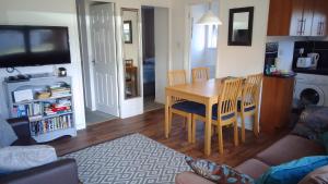 a living room with a table and chairs and a kitchen at The Nest in Hemsby