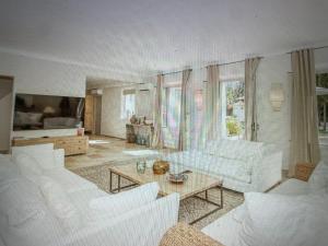 a living room with white couches and a table at Villa Sunset Bay in Baja Sardinia