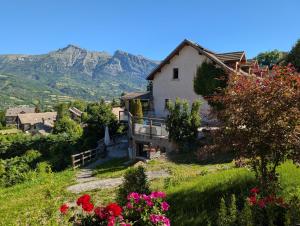 a house on a hill with mountains in the background at Les Garianes in Saint-Léger-les-Mélèzes