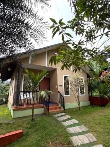a house with a palm tree in front of it at Wayanad Way Resort in Koroth +41 photos