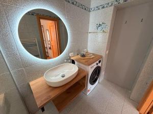 a bathroom with a sink and a mirror at Appartamento Girasole - Cadore Apartments in Candide
