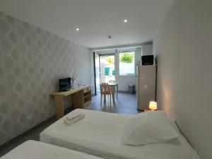 a bedroom with two beds and a desk and a refrigerator at Locaplage in Lanton
