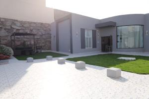 a house with a patio with a yard with grass at شاليهات تايم in Khamis Mushayt