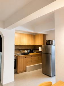 a kitchen with wooden cabinets and a stainless steel refrigerator at Downtown View Apartment - Rhodes in Rhodes Town