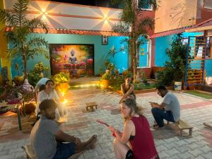 a group of people sitting around in a courtyard at Thilo Guest House Auroville in Auroville