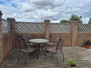a patio with a table and chairs on a wooden deck at Highlands in Pinchbeck