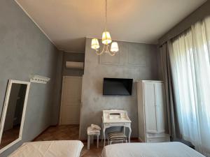 a bedroom with two beds and a table and a television at Boutique Hotel Washington Milano - JCUBE HOTELLERIE in Milan