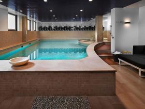 a swimming pool in a building with a pool at Sofitel Legend The Grand Amsterdam in Amsterdam