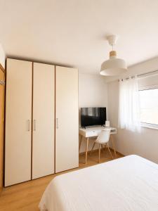 a white bedroom with a bed and a desk at Downtown View Apartment - Rhodes in Rhodes Town