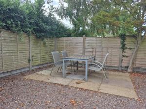 a table and chairs in front of a fence at Highlands in Pinchbeck