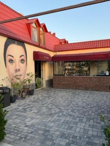 a building with a face painted on the side of it at Very Well Guest House in Baku