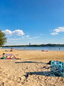 a beach with people laying on the sand at Apartman Amal in Vukovar
