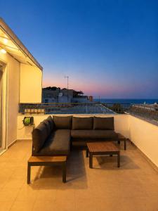 a couch sitting on a balcony with a view of the ocean at Downtown View Apartment - Rhodes in Rhodes Town