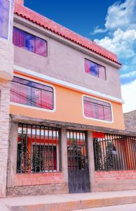un edificio con ventanas de barrotes en una calle en Residencial Norandes, en Huaraz