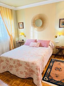 a bedroom with a large bed and a mirror at Piso céntrico y luminoso in León
