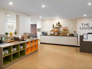 a large kitchen with a counter in a restaurant at Mercure Melbourne City Centre in Melbourne