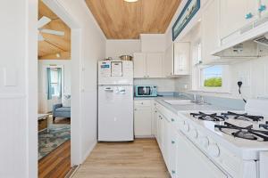 a kitchen with a white refrigerator and a stove at Beach Home With Beautiful Ocean Views in Dennis