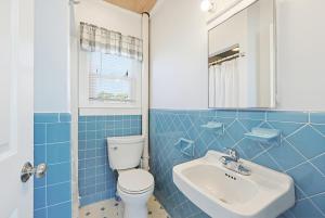 a blue tiled bathroom with a toilet and a sink at Beach Home With Beautiful Ocean Views in Dennis +30 photos
