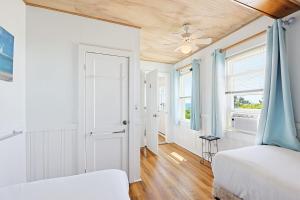 a bedroom with two beds and a ceiling fan at Beach Home With Beautiful Ocean Views in Dennis