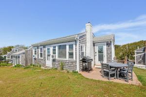 a small house with a picnic table in the yard at Beach Home With Beautiful Ocean Views in Dennis