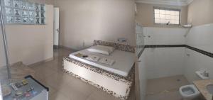 a bathroom with a bed and a shower in it at Motel Classe A in Limeira