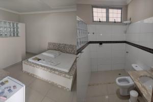 a white bathroom with a toilet and a sink at Motel Classe A in Limeira