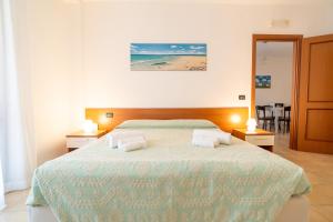 a bedroom with a large bed with two night stands at Residence Le Fontane in Villasimius +60 photos