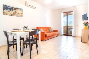 a living room with a table and chairs and a couch at Residence Le Fontane in Villasimius