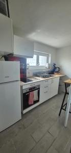 a kitchen with white cabinets and a stove top oven at Chez T-E-O in Cognac