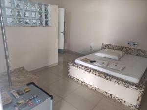 a small room with a bed and a refrigerator at Motel Classe A in Limeira