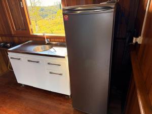 a refrigerator in a kitchen with a sink and a window at CABANAS BELVEDERE SERRA DO RiO DO RASTRO in Lauro Müller
