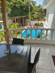 a balcony with a table and chairs and a swimming pool at HUMMINGBIRD Hotel Cabarete in Cabarete