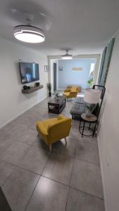 a living room with yellow chairs and a couch at Acogedora Casa in El Sauzal