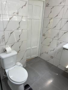 a bathroom with a white toilet and a door at HUMMINGBIRD Hotel Cabarete in Cabarete