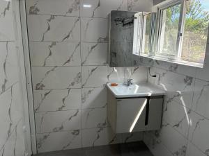 a white bathroom with a sink and a window at HUMMINGBIRD Hotel Cabarete in Cabarete +95 photos
