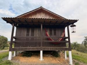 a small building with a roof and a porch at CABANAS BELVEDERE SERRA DO RiO DO RASTRO in Lauro Müller