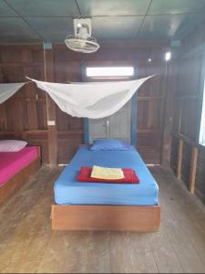 a bed in a boat with a mosquito net at Nature Dormitory in Ban Donsôm Tai